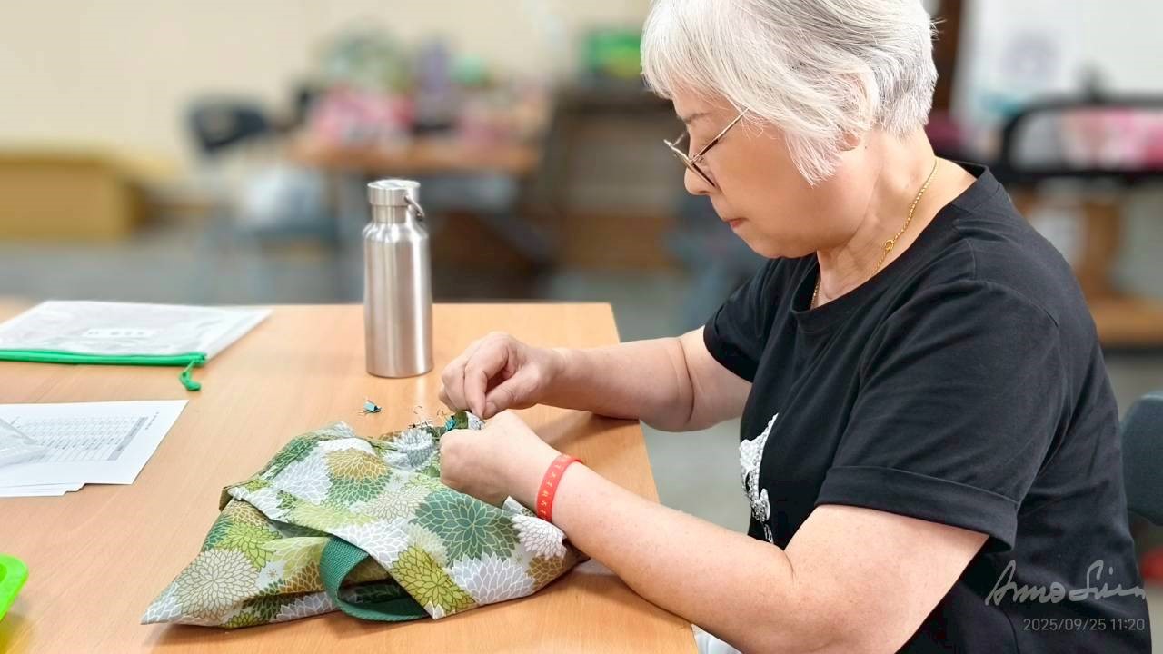 認真的專注的縫制合併袋子部份